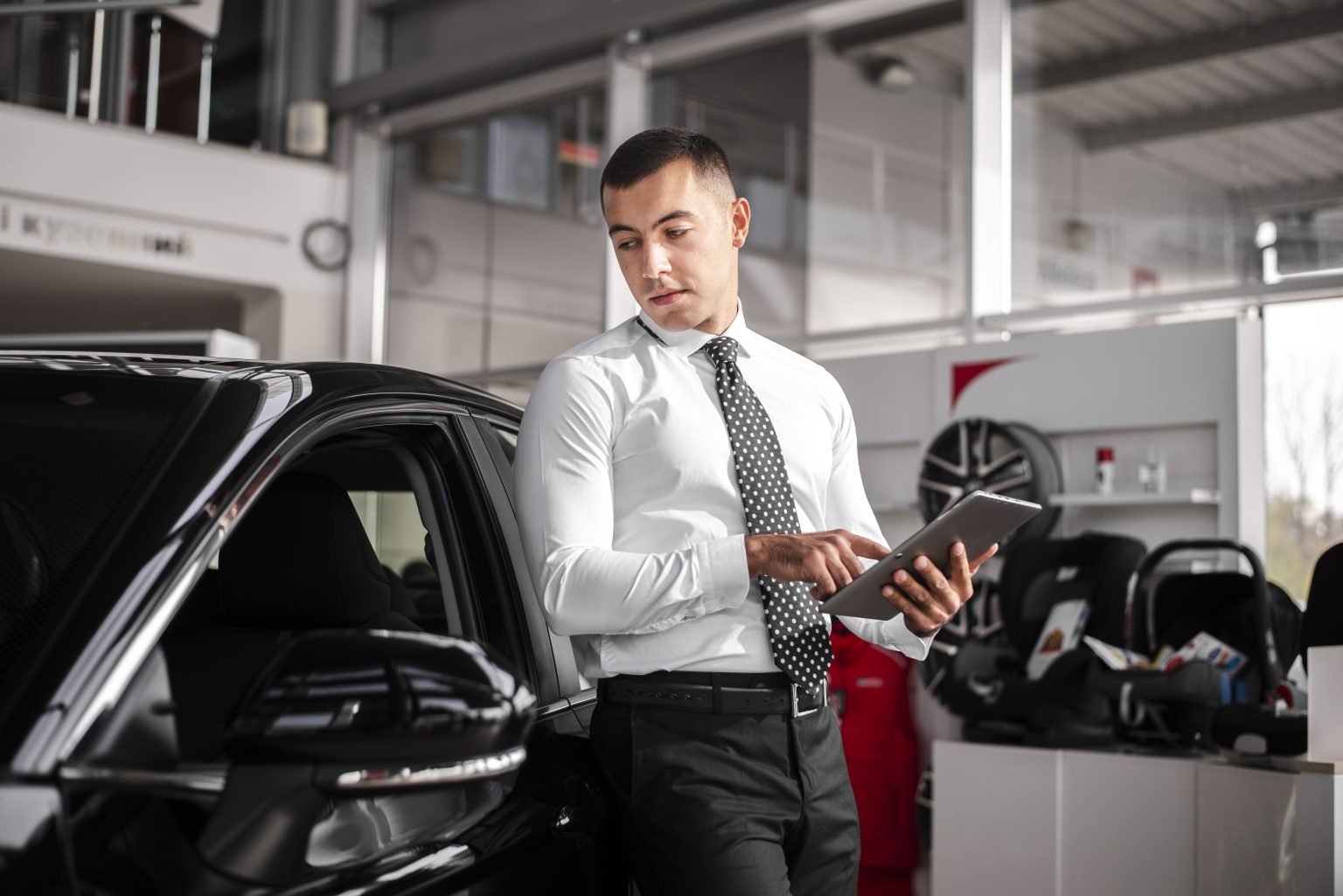 front-view-male-car-dealer-with-tablet